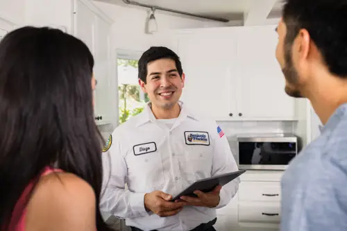 Benjamin Franklin Plumbing Tech, Diego, speaking with homeowners in their Niceville FL home