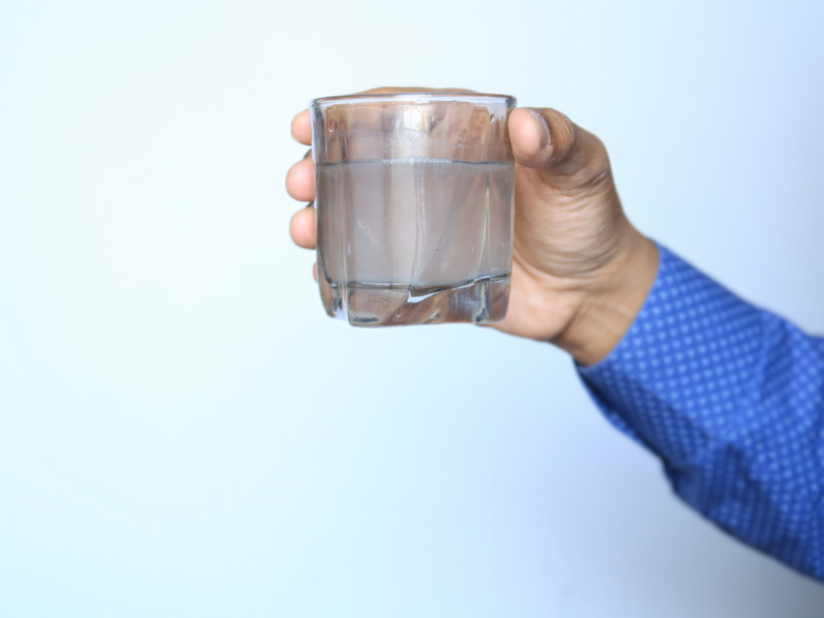 man examining quality of water in his drinking glass