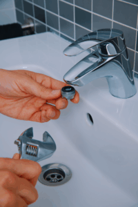 Plumber removing stuck aerator